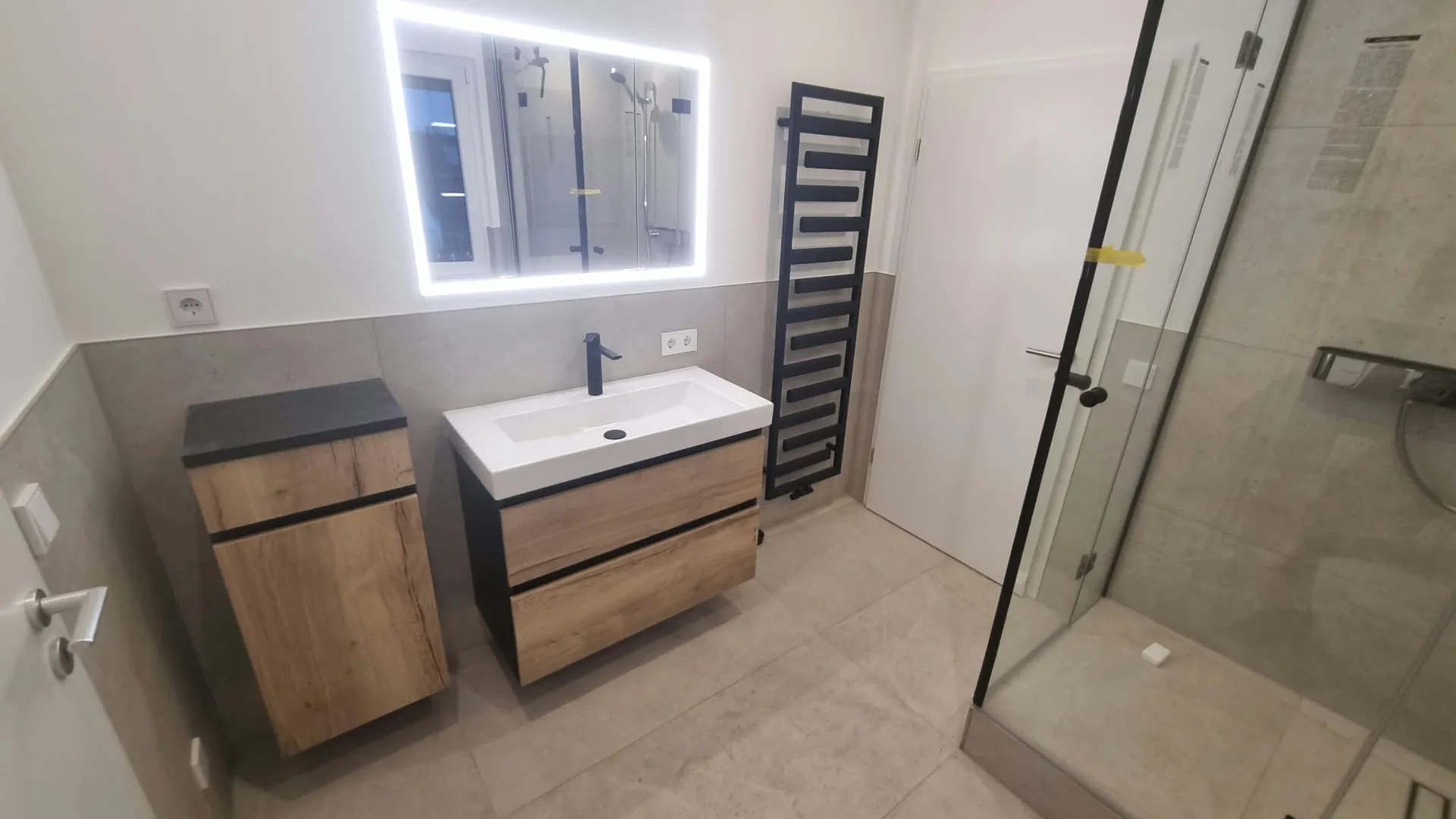 Modernes Badezimmer mit Holzvanity und Glaskabine