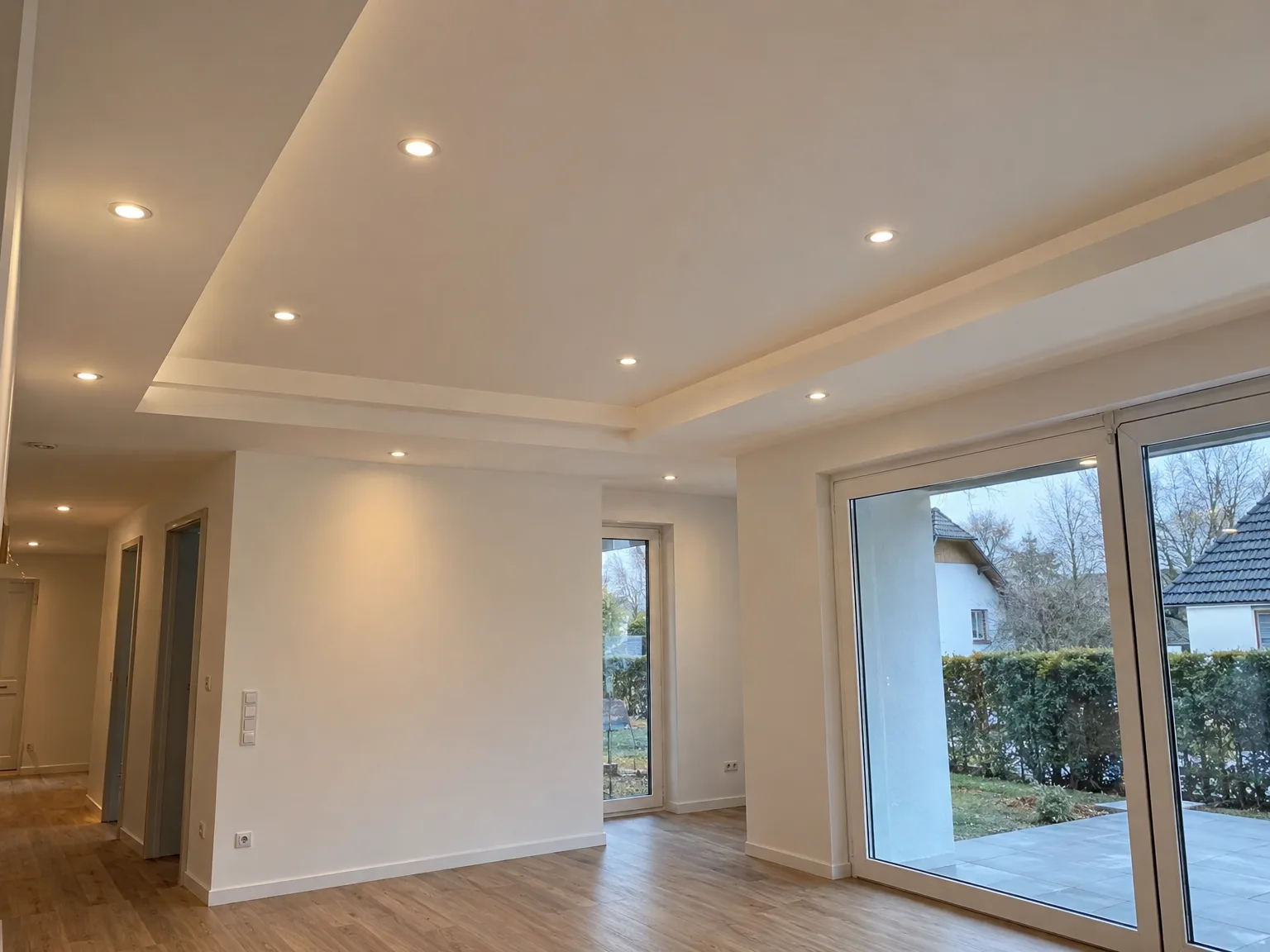 Modernisiertes Wohnzimmer mit neuer abgehängter Decke, LED-Spots und Holzboden