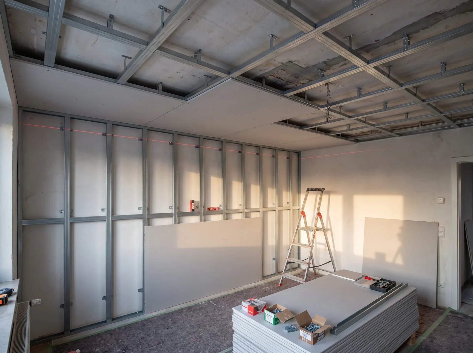 Trockenbau: Montage von Metallprofilen und Gipskartonplatten zur Wandverkleidung im Rohbau