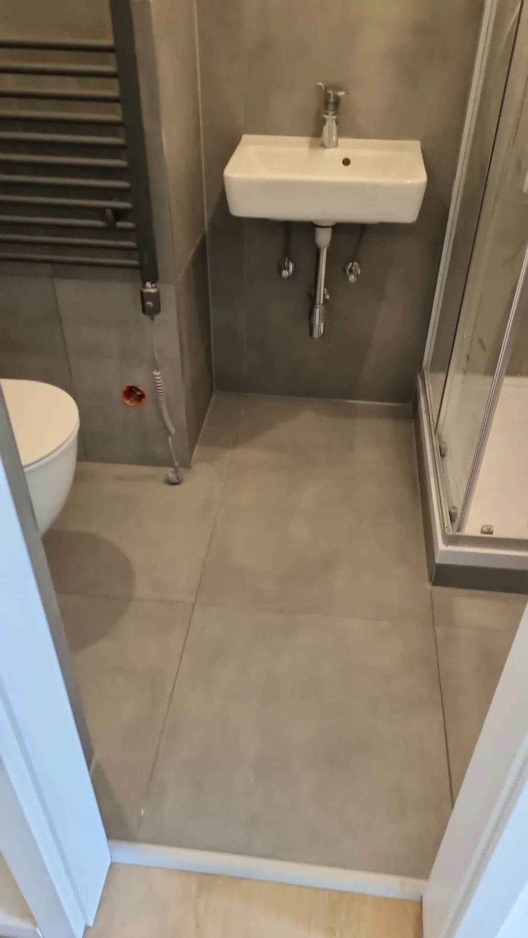 Renoviertes Gäste-WC mit Wandwaschtisch, Fliesenarbeiten und moderner Dusche