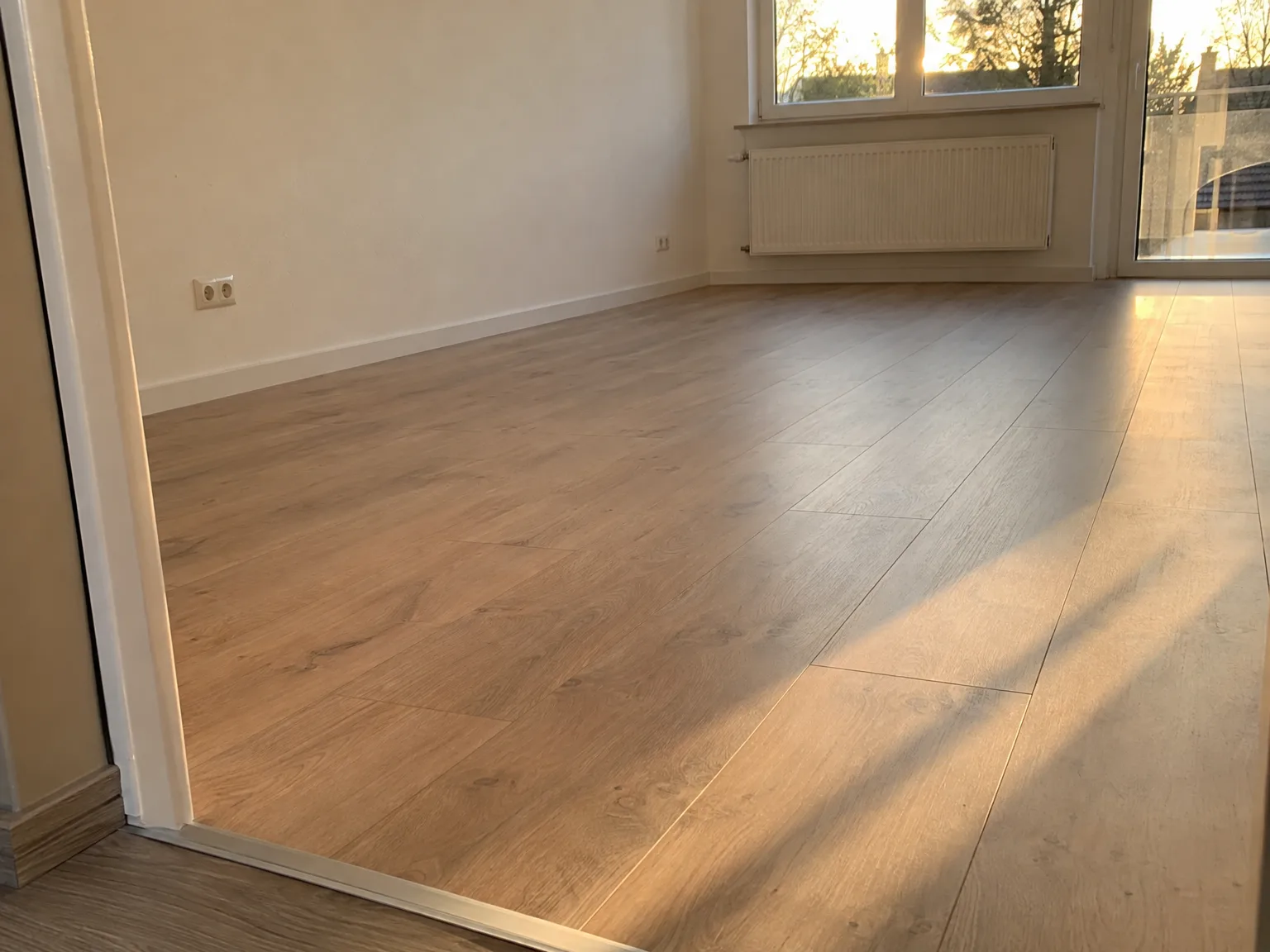 Neu verlegte Parkettboden in warmen Brauntönen, professionell verlegt und hell erleuchtet