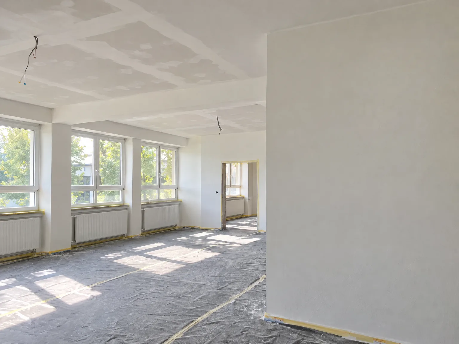 Wohnzimmer mit neu verlegter abgehängter Gipskarton-Decke und hellen Wänden